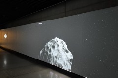 Passageway showing animation of a meteor tumbling through space.
